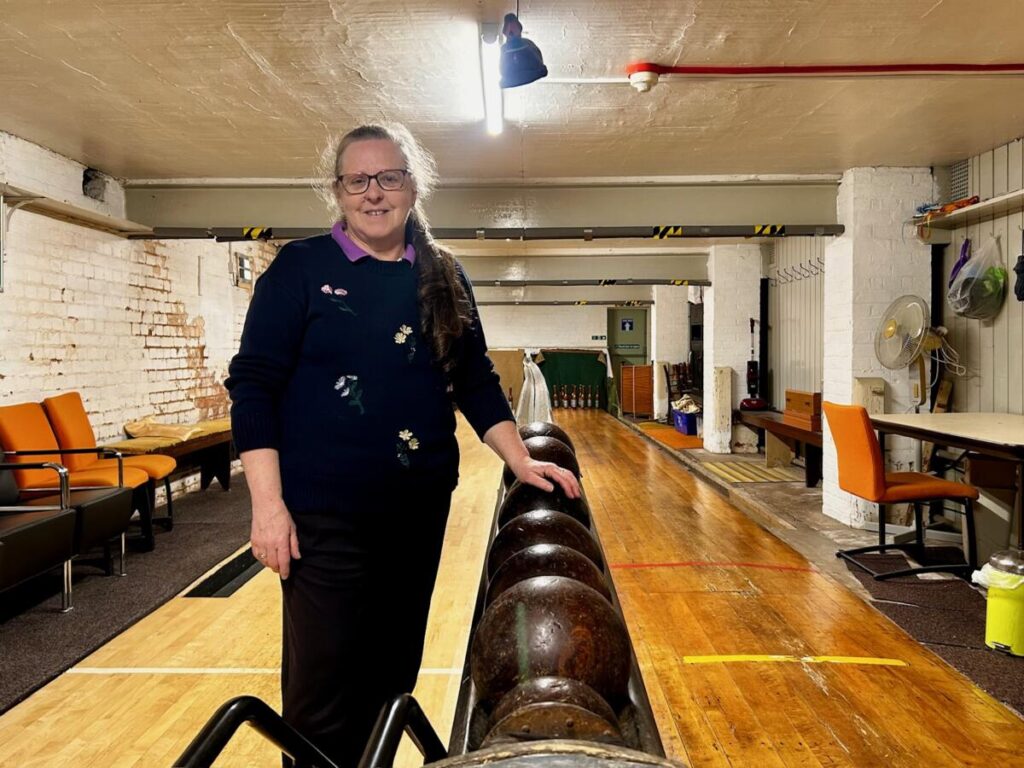 Tina standing next to a rack of bowling balls