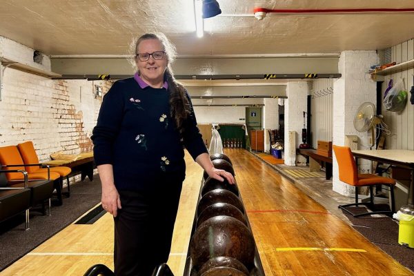 Tina standing next to a rack of bowling balls